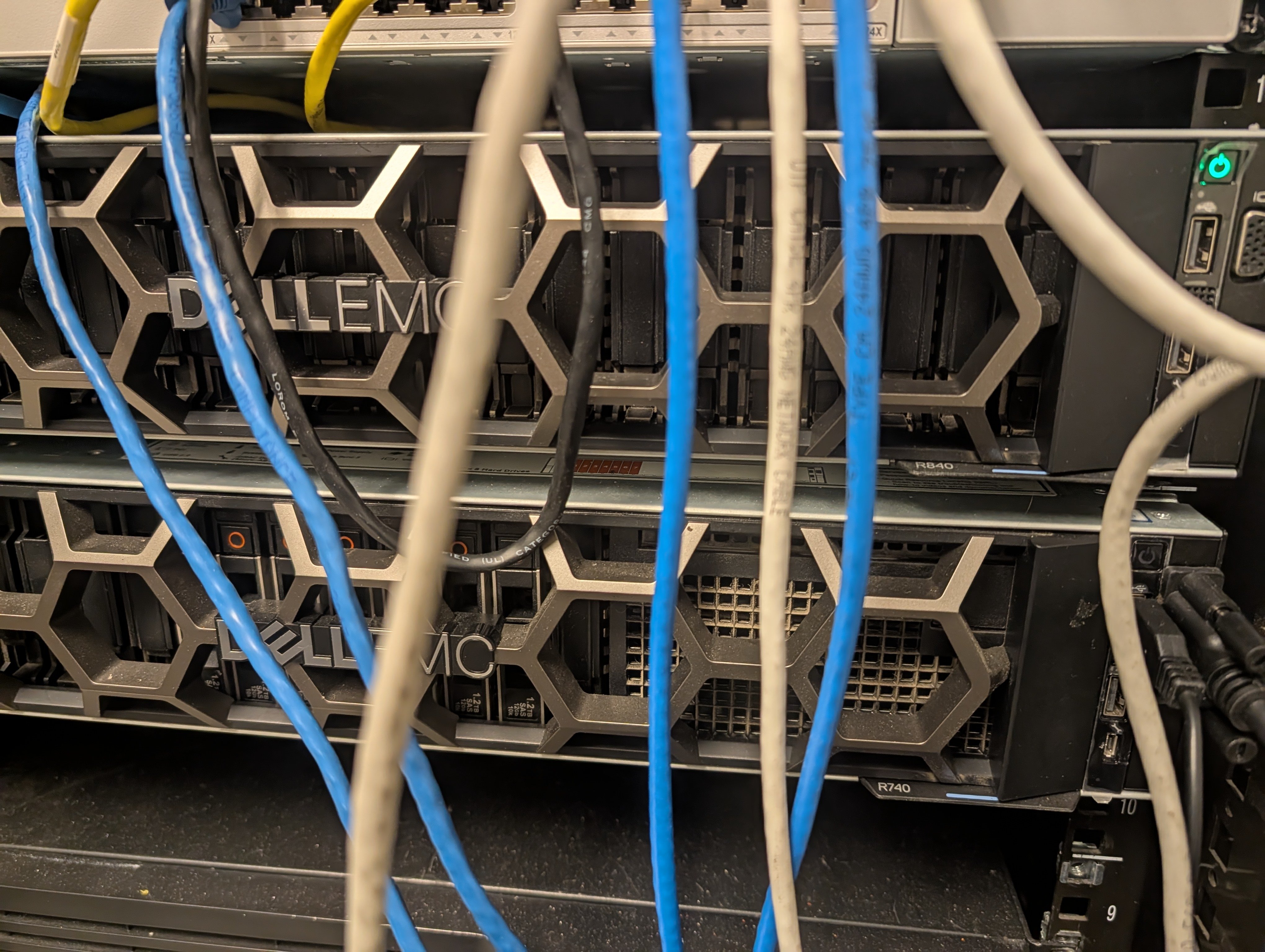 Vista cercana de servidores Dell EMC PowerEdge y cableado de red en el rack de laboratorio de LaneCert.